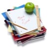 Stack of school notebooks & folders with a pencil, ruler, and green apple.